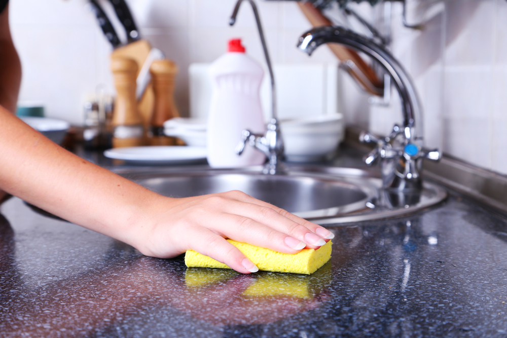 Image of a gloved hand cleaning a marble kitchen counter | Kim Kleans